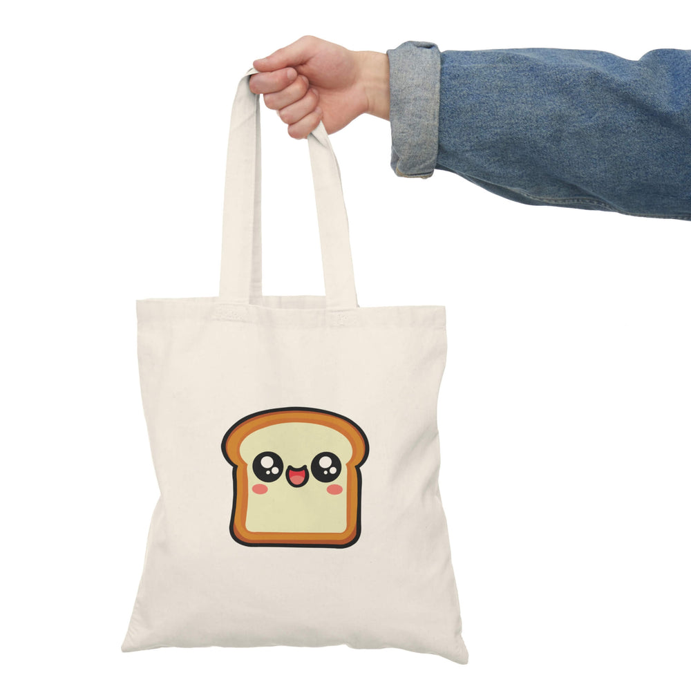 A natural beige tote bag featuring a cute, smiling slice of bread with big, sparkling eyes and rosy cheeks. Made from 100% recycled cotton, this eco-friendly bag is lightweight yet durable. Perfect for shopping, carrying books, or adding a touch of fun to everyday outfits.

