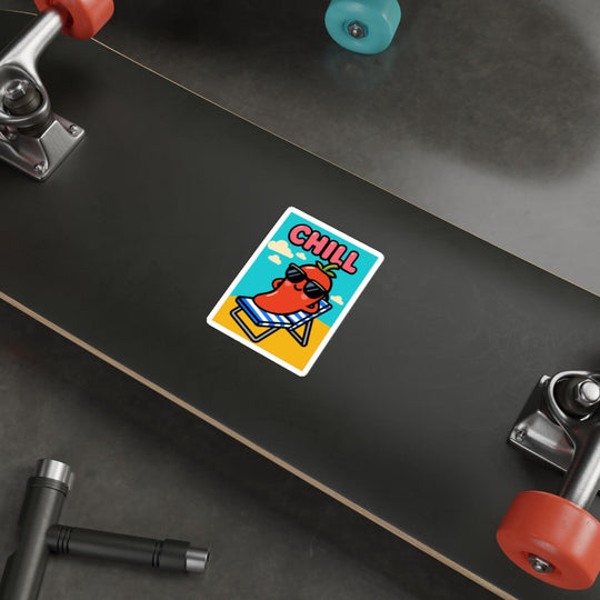 Funny cartoon pepper with sunglasses reclining in a beach chair under the word “CHILL,” in bold poster-style design on a vinyl sticker applied to a skateboard.