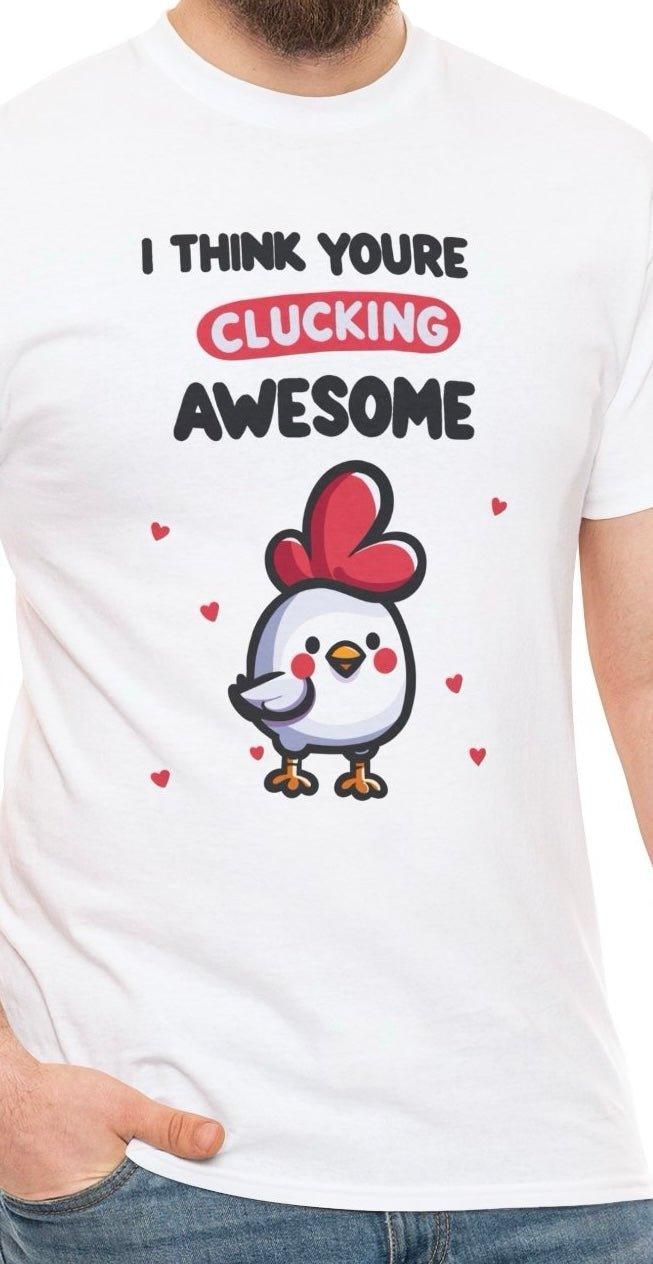 A person is sporting the "Clucking Awesome Chicken" Inspirational T-Shirt from Baby Keo, featuring a quirky cartoon chicken with a red comb surrounded by hearts. The phrase "I THINK YOU'RE CLUCKING AWESOME" makes it an ideal humorous gift for anyone who appreciates a good laugh.