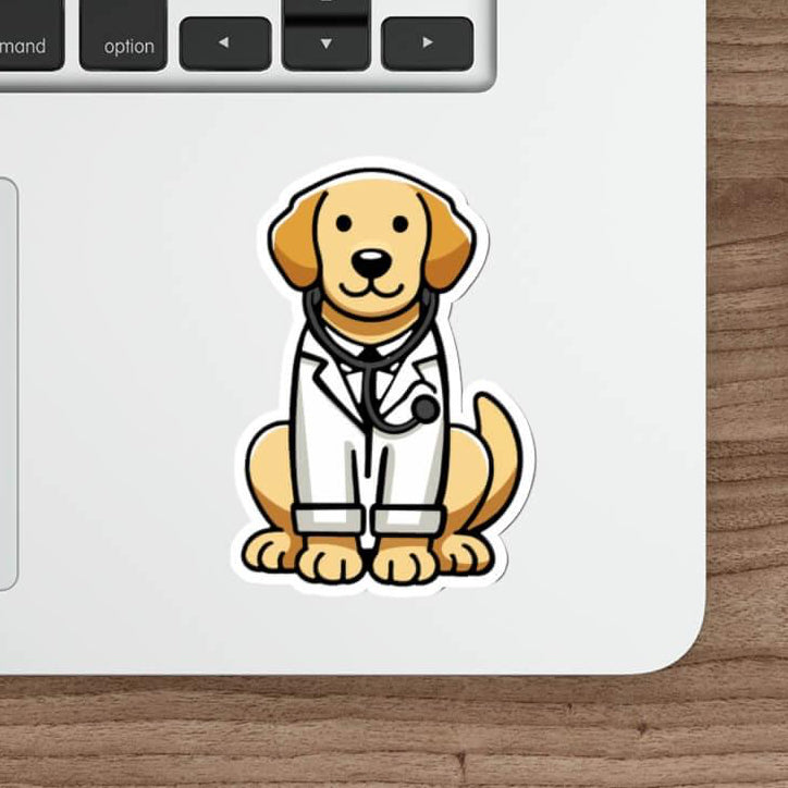A cute, illustrated sticker of a golden retriever dressed as a doctor, wearing a white lab coat and stethoscope, placed on a sleek laptop near a keyboard and mouse on a wooden desk.