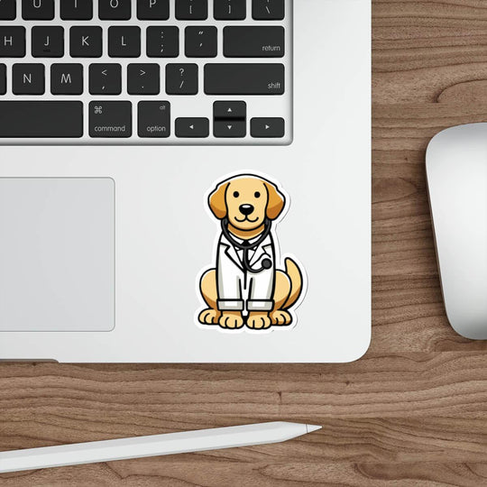 A cute, illustrated sticker of a golden retriever dressed as a doctor, wearing a white lab coat and stethoscope, placed on a sleek laptop near a keyboard and mouse on a wooden desk.