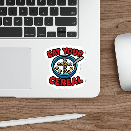 Christian cereal sticker featuring a bowl of Cheerios shaped into a cross with the text “Eat Your Cereal” in bold red font, placed on a laptop.