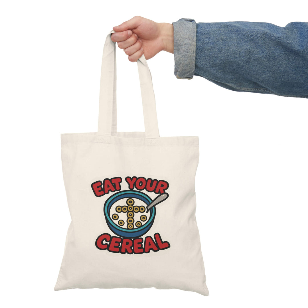 Faith-inspired funny tote bag with ‘Eat Your Cereal’ design featuring a cross made of cereal in a bowl – reusable cotton bag by Keolix