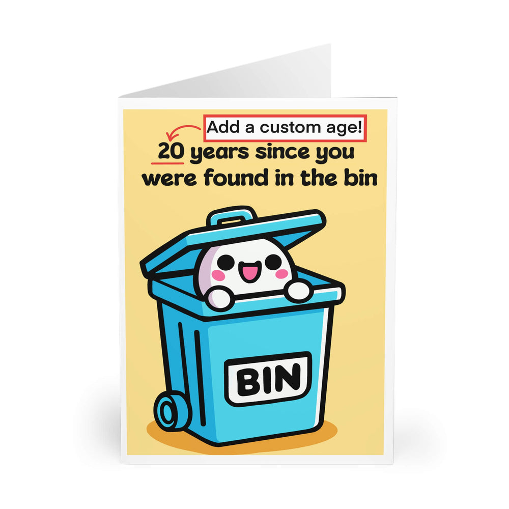 A humorous, customizable greeting card featuring a cute cartoon character popping out of a blue trash bin with "BIN" written on it. The text reads, "20 years since you were found in the bin," with the option to personalize the age