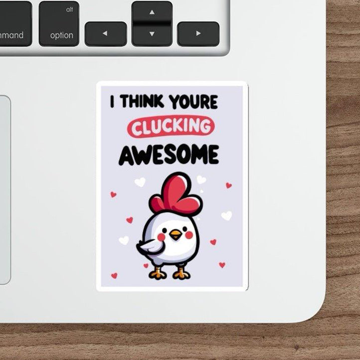 A sticker with a graphic of a chicken wearing a heart-shaped hat and text 'I THINK YOU'RE CLUCKING AWESOME' placed on a laptop.