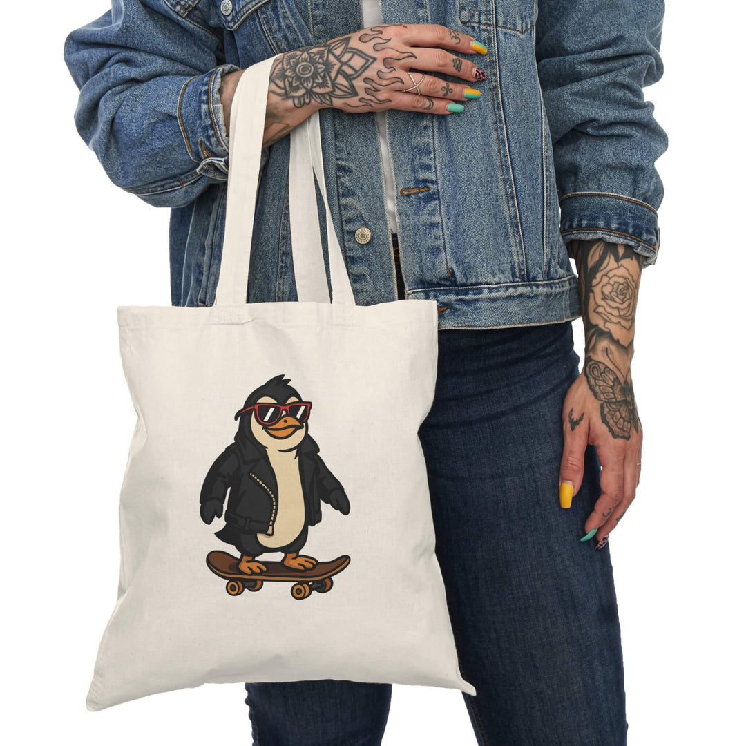Tote bag with a cartoon penguin wearing a leather jacket and red sunglasses, riding a skateboard. Printed on natural cotton canvas.
