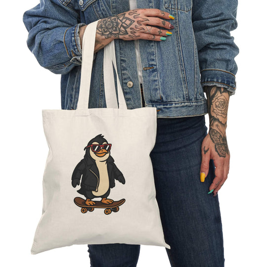 Tote bag with a cartoon penguin wearing a leather jacket and red sunglasses, riding a skateboard. Printed on natural cotton canvas.