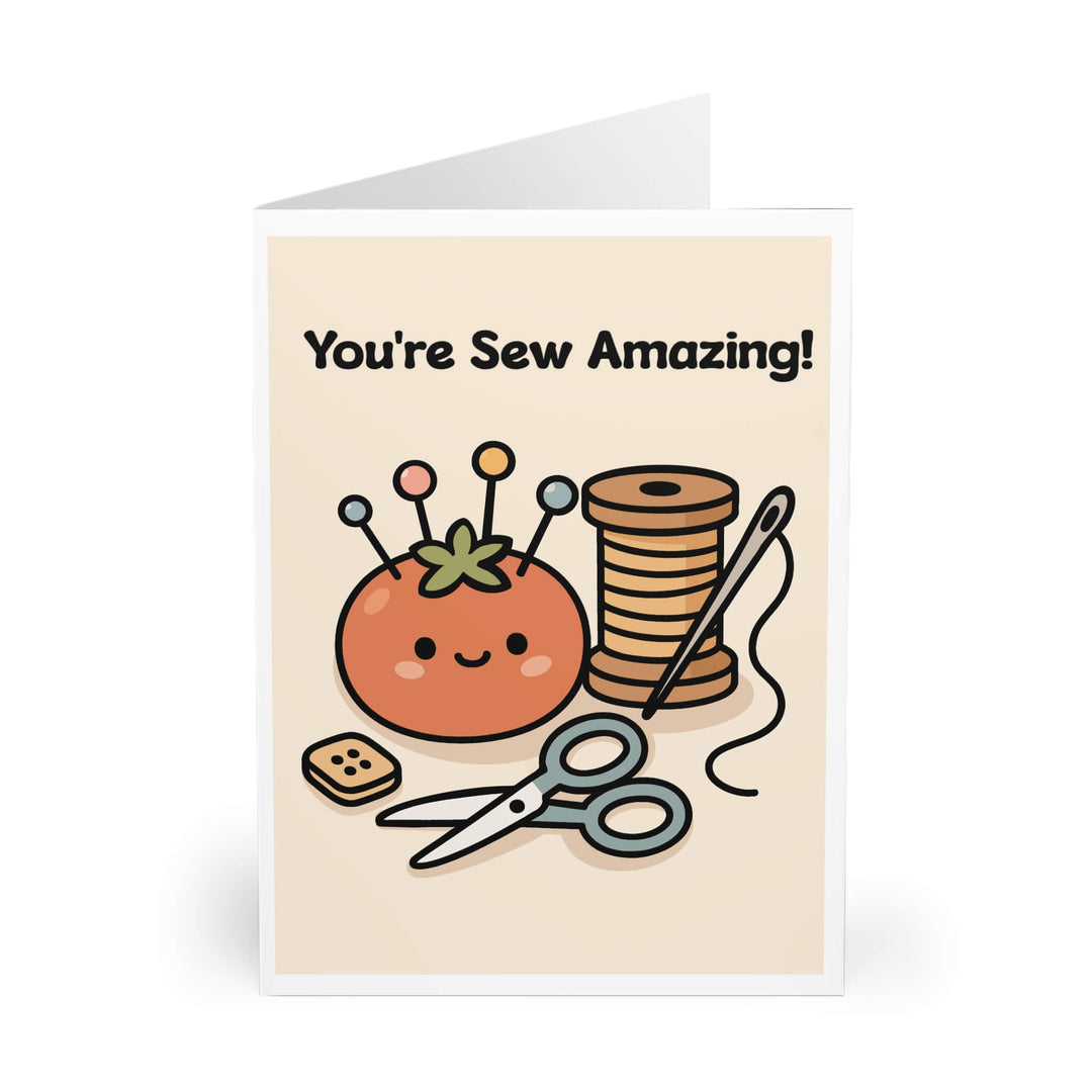 Cute sewing-themed greeting card featuring a smiling pincushion, spool of thread, scissors, button, and needle, with playful text “You’re Sew Amazing!