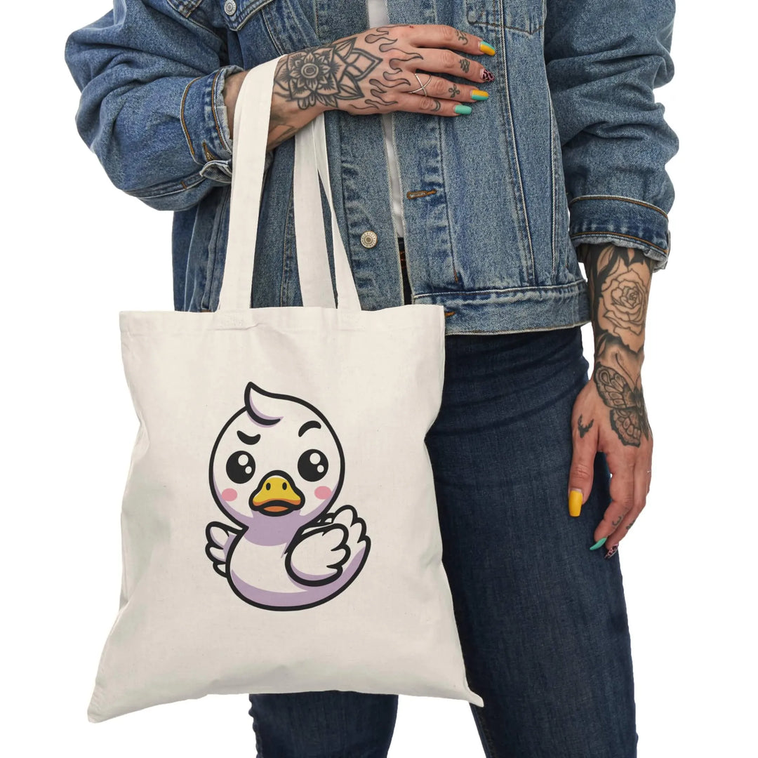 A natural cotton tote bag featuring a feisty and adorable white duck illustration with a determined expression. Perfect for everyday use and eco-friendly shopping.

