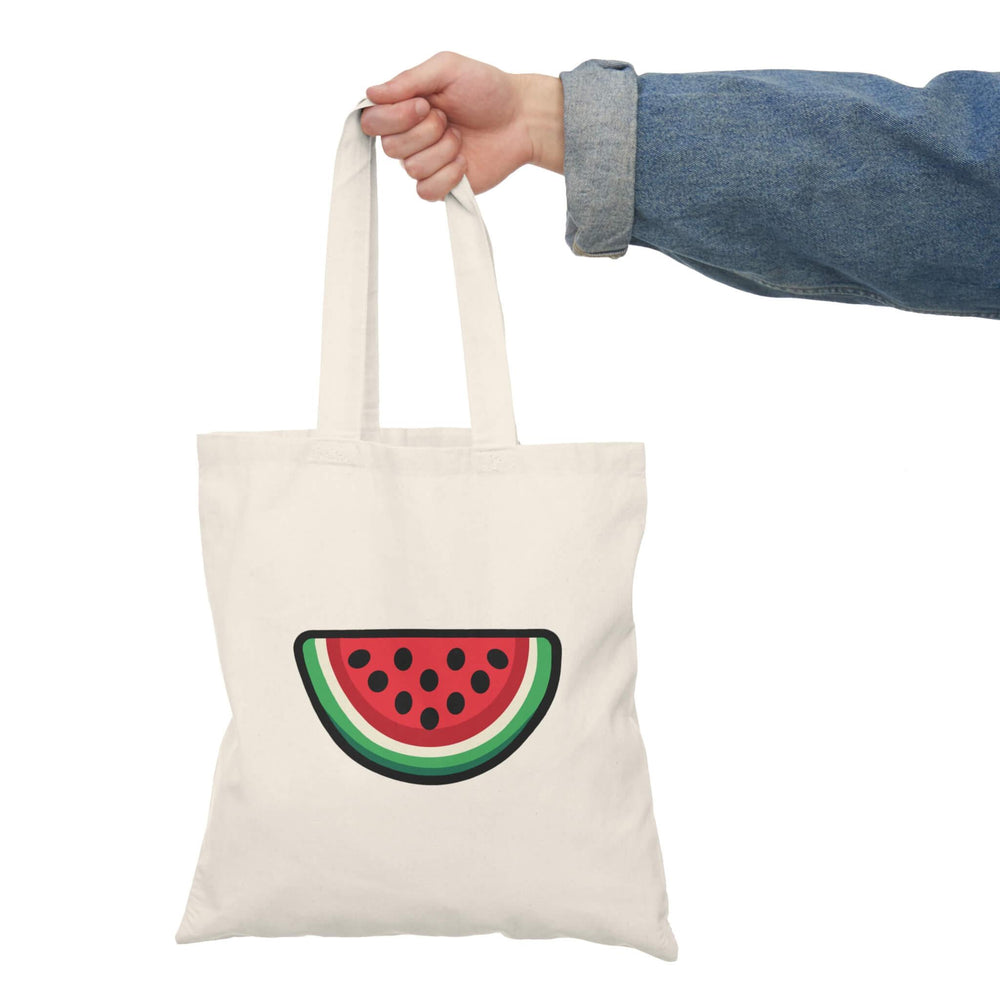 Watermelon tote bag featuring a vibrant, cartoon-style watermelon slice design with red flesh, black seeds, and green rind. Made of 100% recycled cotton.

