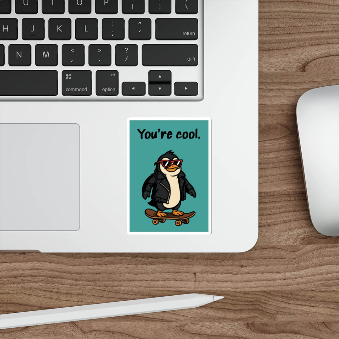 Laptop with a penguin sticker on a wooden desk